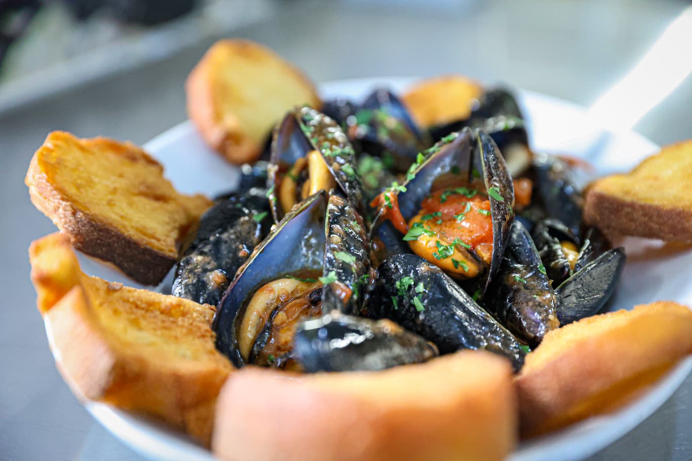 Chef che rifinisce il sauté con un filo d'olio